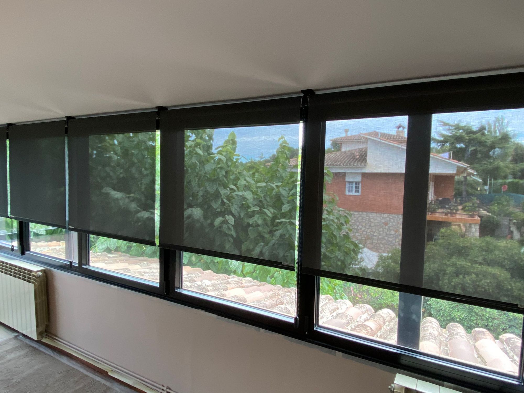 Cortinas enrollables con tejido técnico screen de color negro instaladas en ventanas de vivienda en Cobera del Llobregat
